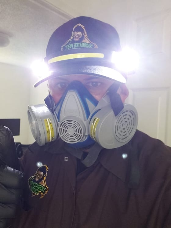 Kristofer Elling in a branded cap with twin cap lights and a half-face respirator, gloved and ready to treat aboard a boat