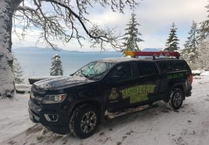 Sasquatch Pest Control truck in the snow by a lake in Whatcom County WA